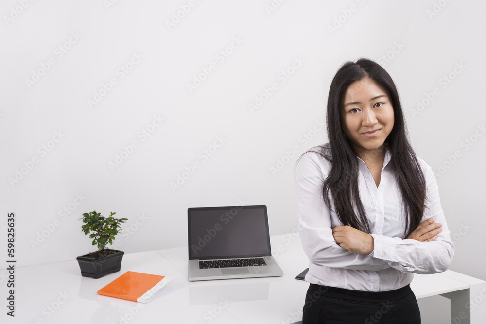 Portrait of confident businesswoman standing arms crossed in office Portrait of confident businesswoman standing arms crossed in office
