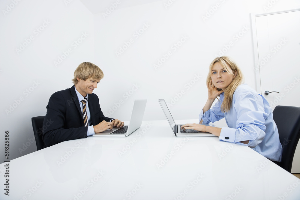 Portrait of businesswoman with coworker working in office Portrait of businesswoman with coworker working in office