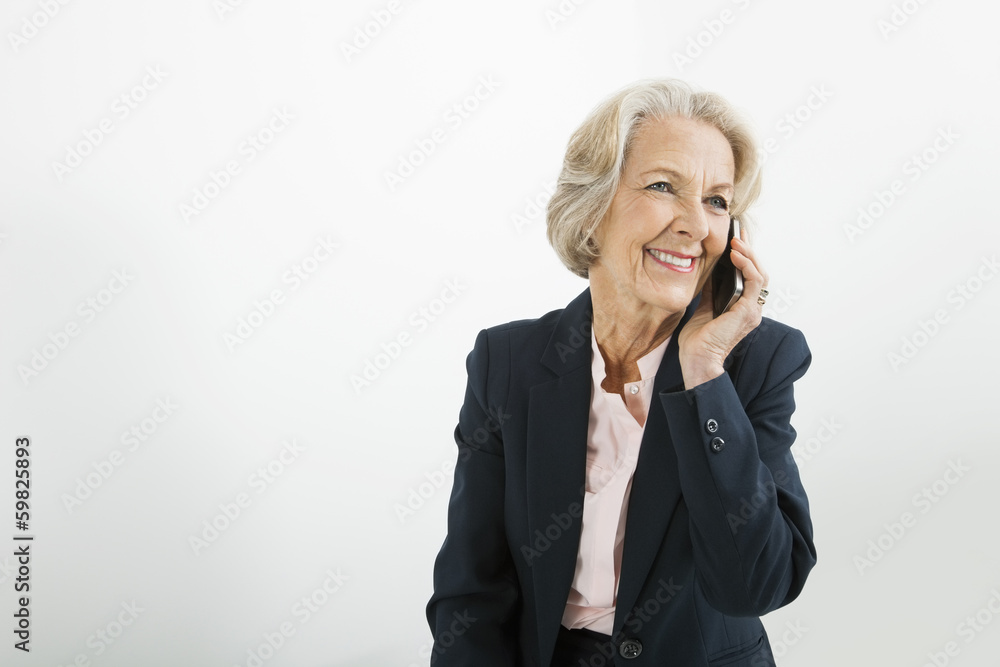 Senior businesswoman using cell phone in office
