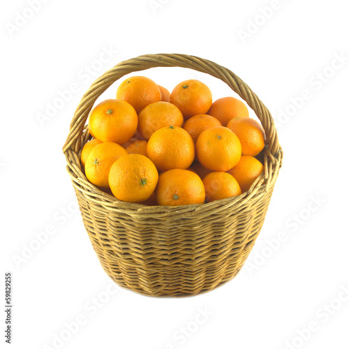 Many orange tangerines in wicker basket isolated closeup