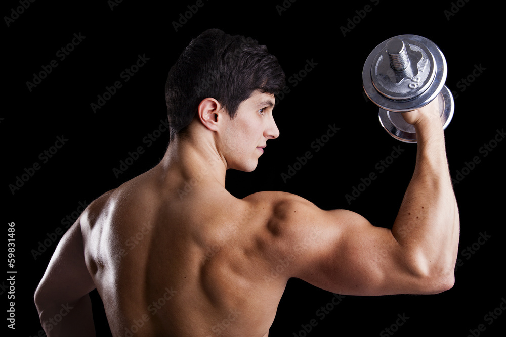 Portrait of a strong man lifting weights against a dark backgrou Portrait of a strong man lifting weights against a dark backgrou