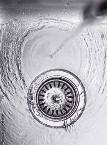 Water flowing down the hole in a kitchen sink
