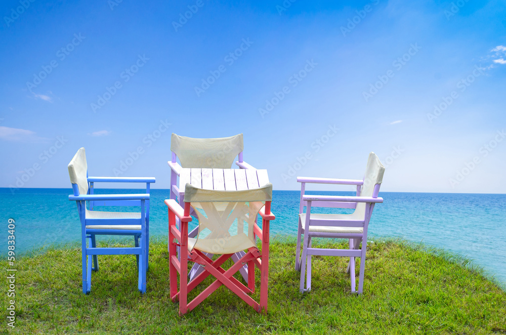 Chairs and table on the grass, sea in the background