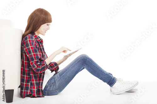 young woman touching tablet and sitting on the floor
