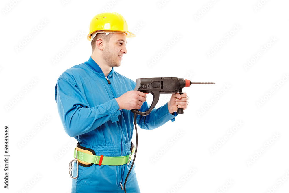 Worker with helmet working with a drill