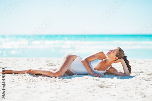 Relaxed young woman laying on beach