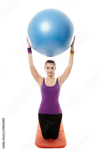 Athletic woman holding a ball and doing stretching