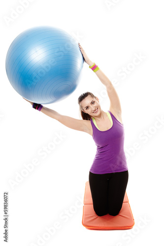 Athletic woman holding a ball and doing stretching