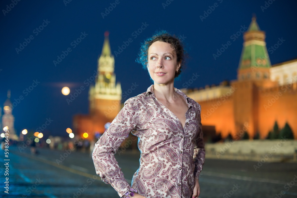 Fototapeta premium Beautiful girl on a red square next to the Kremlin