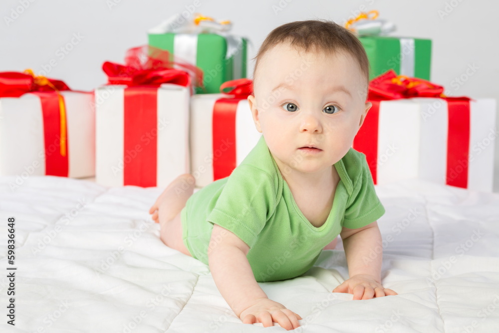 A beautiful baby girl with a gift box on the floor in studio A beautiful baby girl with a gift box on the floor in studio