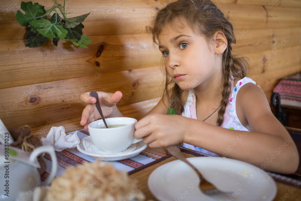 Little girl sitting in a cafe at the table with an empty plate Little girl sitting in a cafe at the table with an empty plate