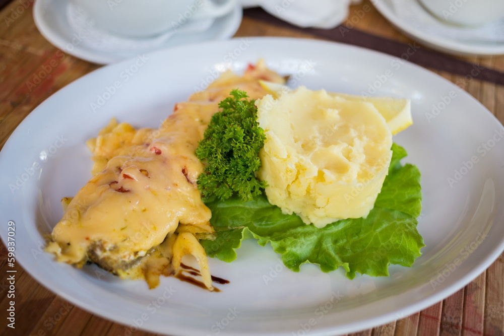 Fish baked with cheese served with mashed potatoes Fish baked with cheese served with mashed potatoes