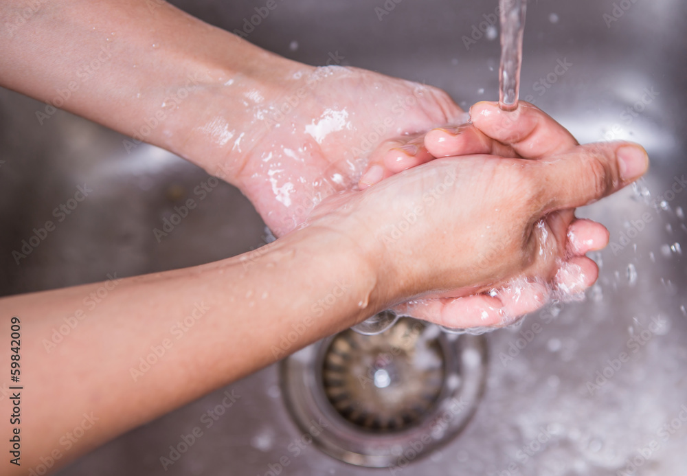 Fototapeta premium Female washing hands at the kitchen sink