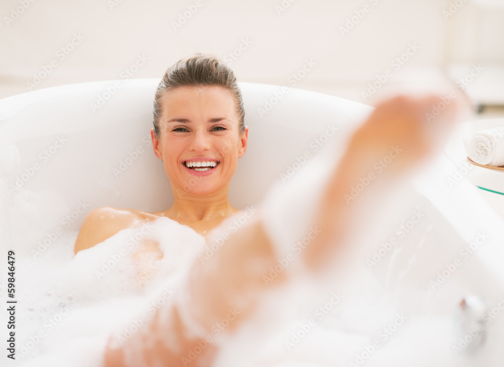 Smiling young woman having fun time in bathtub Smiling young woman having fun time in bathtub