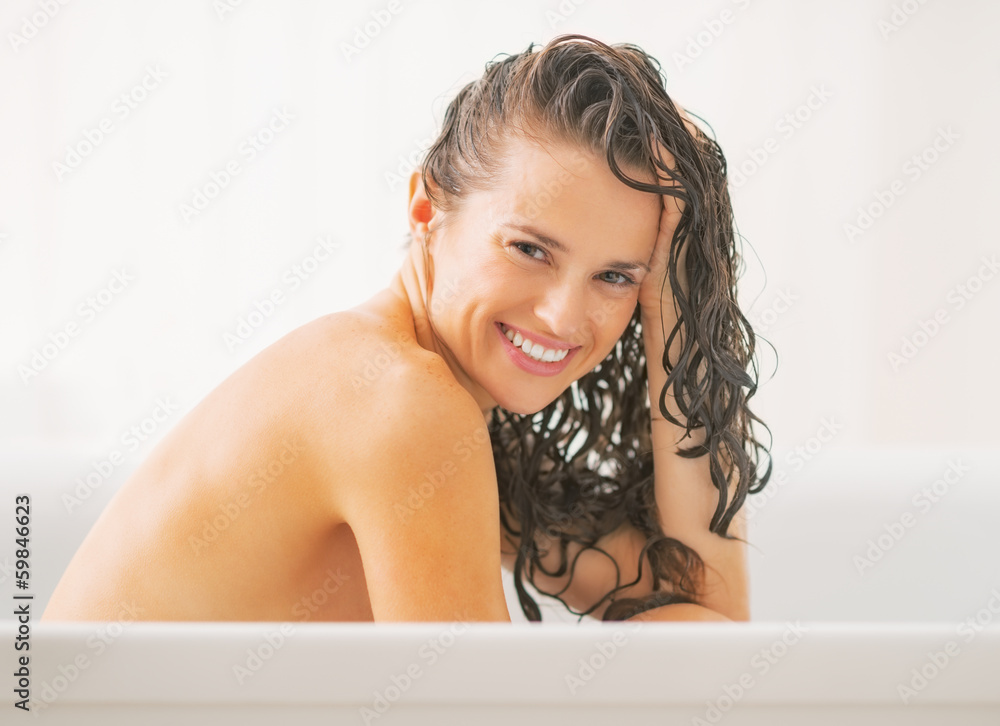Portrait of smiling young woman with wet hair in bathtub Portrait of smiling young woman with wet hair in bathtub