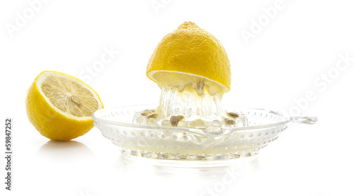 Photography Glass citrus squeezer with lemons and juice on a white backgroun