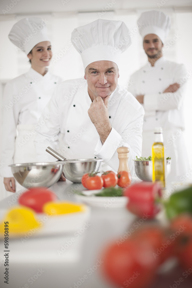 portrait of a senior chef and his team