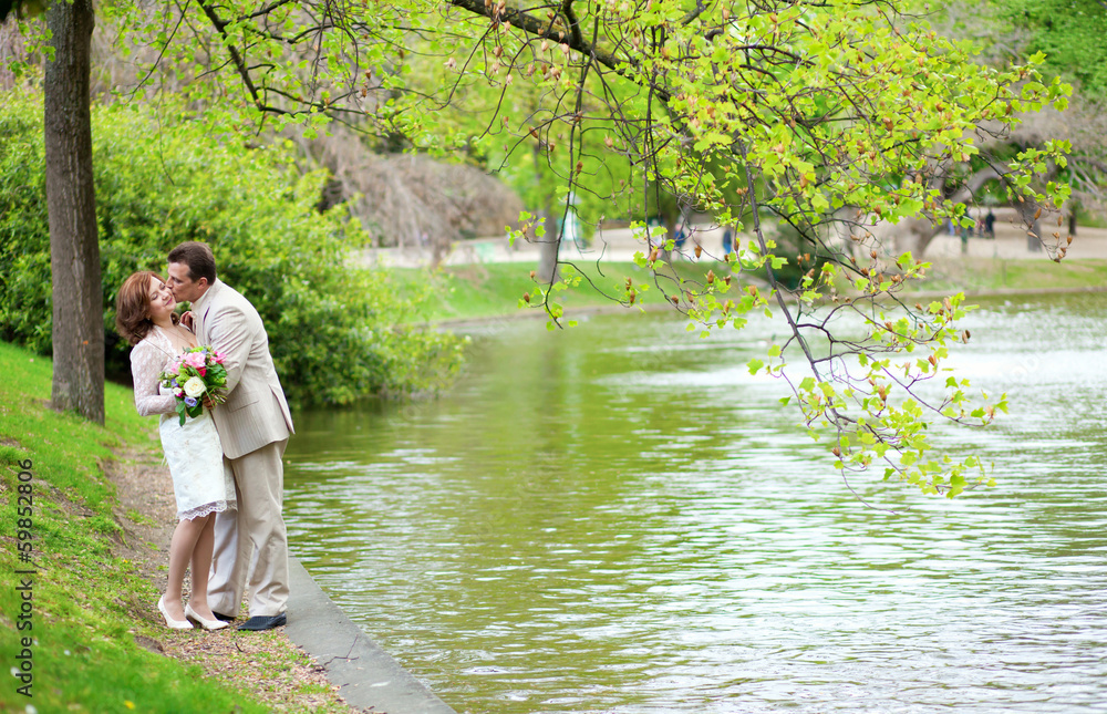 Just married couple hugging and kissing in park Just married couple hugging and kissing in park