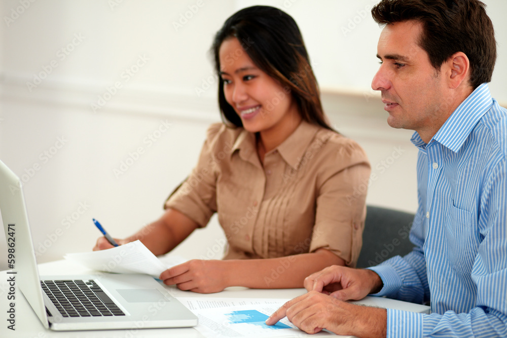 Male and female colleagues working on documents Male and female colleagues working on documents