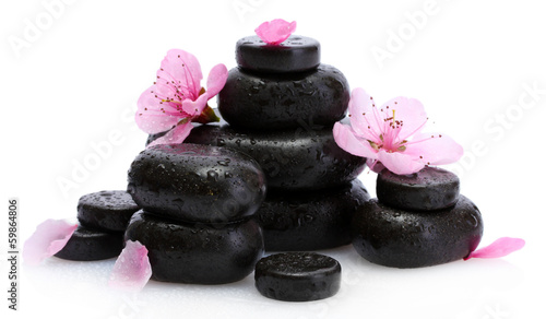 Spa stones with drops and pink sakura flowers isolated on
