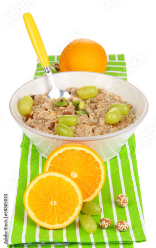 Useful oatmeal in bowl with fruit isolated on white
