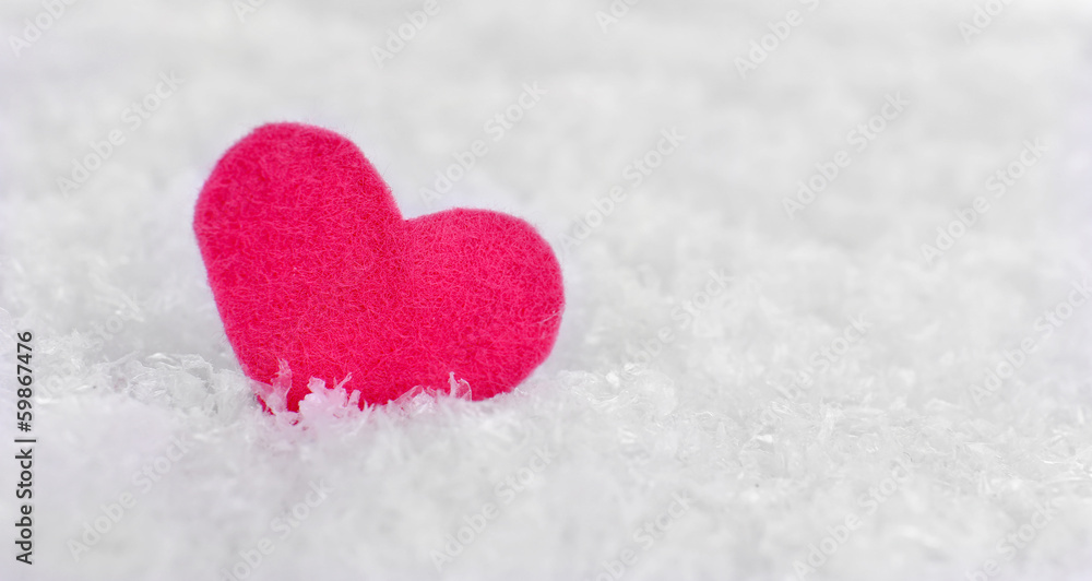 Little felt heart on snowy background
