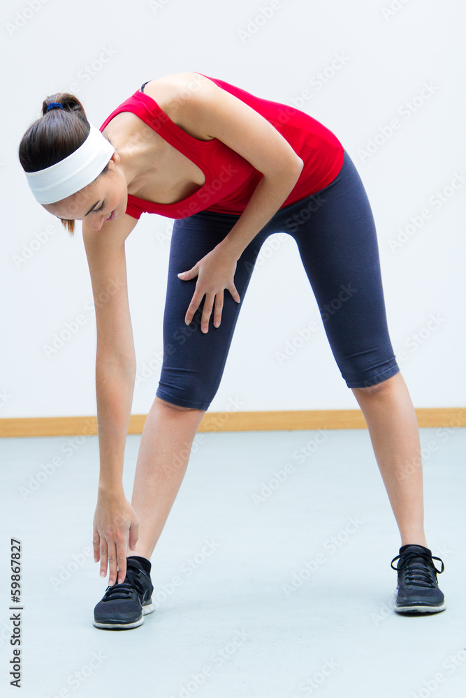 Happy young woman practicing sport in gym