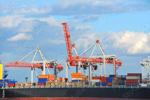 Container stack and ship under crane bridge