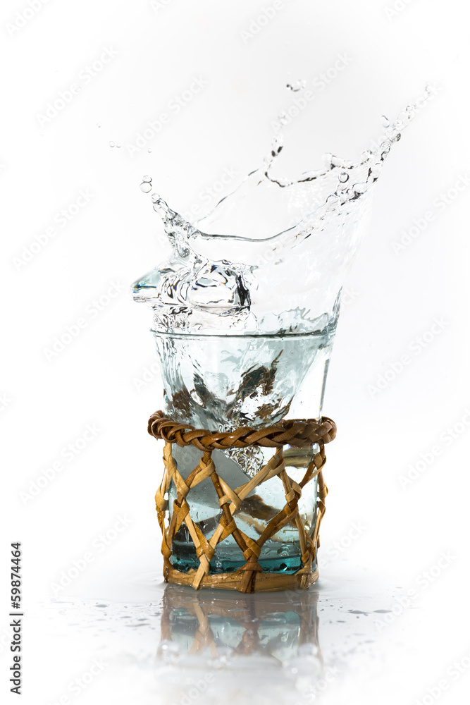 Glaçon qui tombe dans un verre, l'eau déborde et proque des é Stock Photo |  Adobe Stock