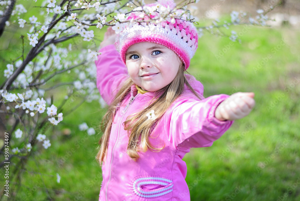 beautiful little girl near a flowering tree beautiful little girl near a flowering tree