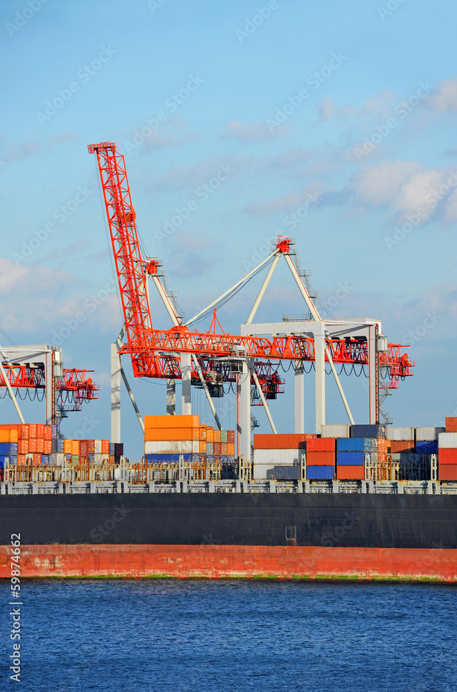 Naklejka premium Container stack and ship under crane bridge