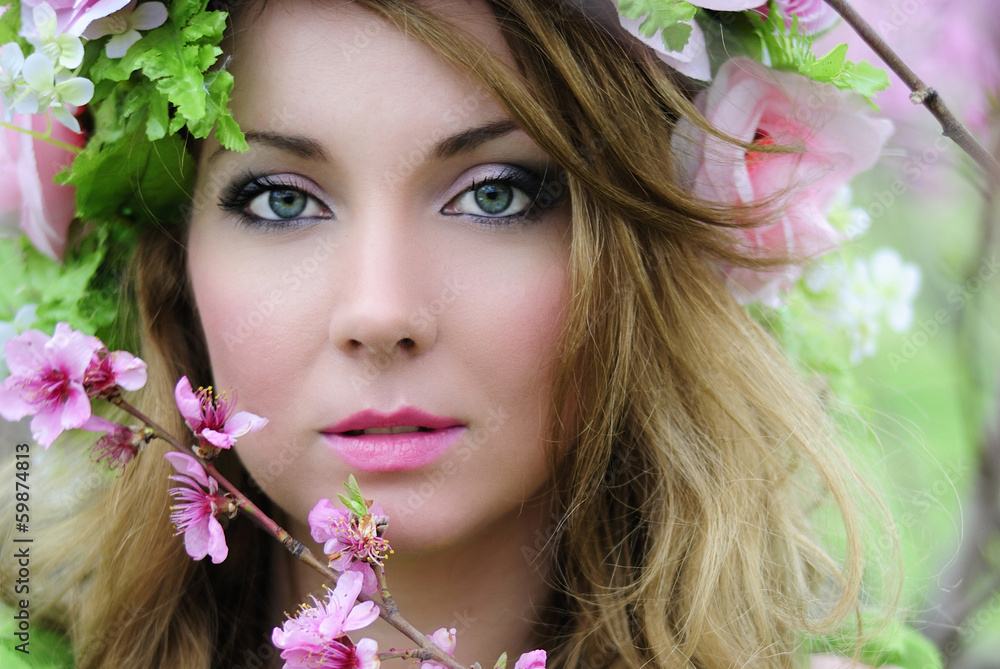 Naklejka premium Beautiful girl in a flowered garden peach