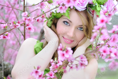 Beautiful girl in a flowered garden peach