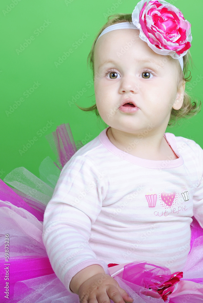 Small girl in rose suit on green background Small girl in rose suit on green background