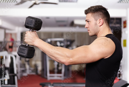 Athletic man working with heavy dumbbells