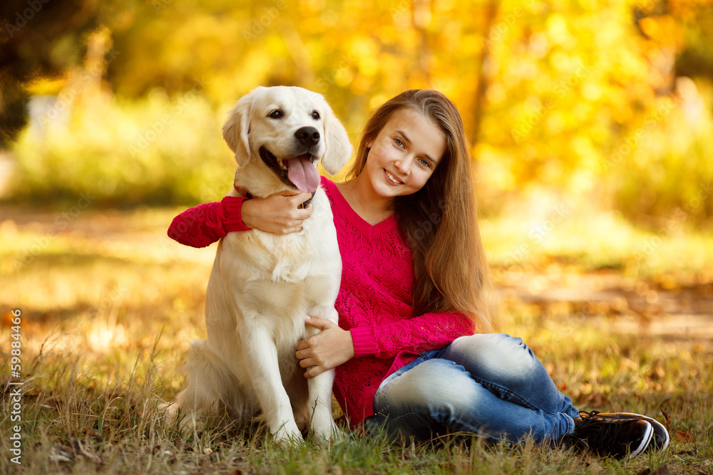 Beautiful woman and her dog posing in autumn park