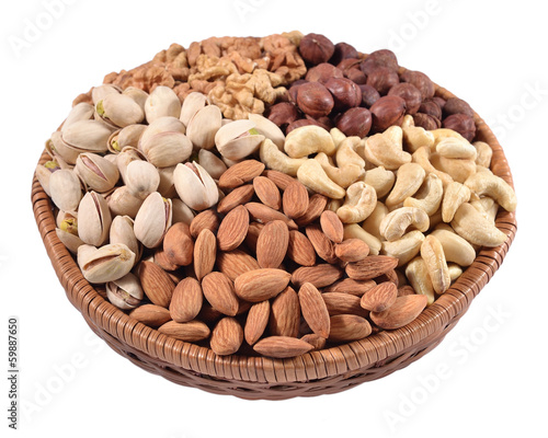 Assorted nuts in a wicker bowl on a white background