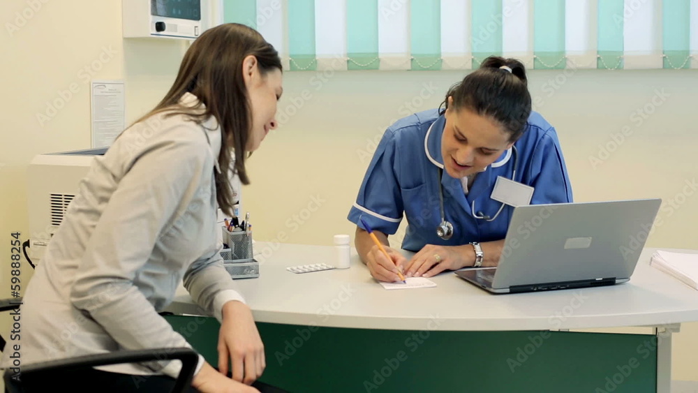 Young female doctor writing rx prescription for female patient Young female doctor writing rx prescription for female patient