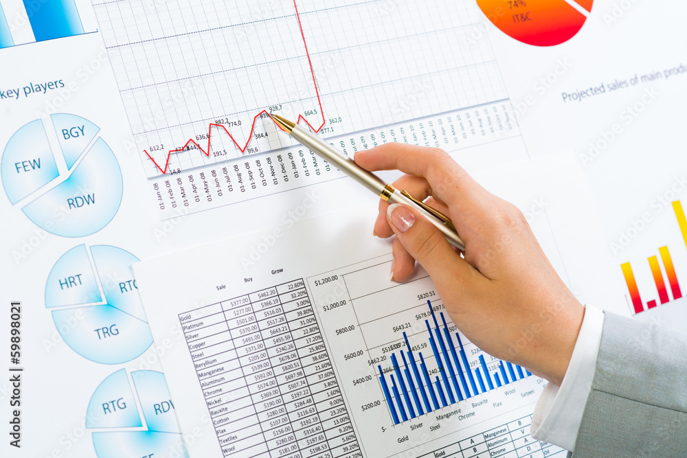 female hand pointing pen on financial charts female hand pointing pen on financial charts