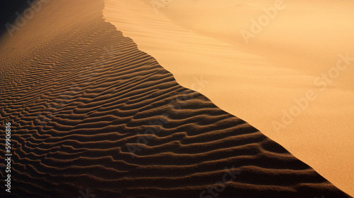 Sand texture with light and shadows and wind-created waves