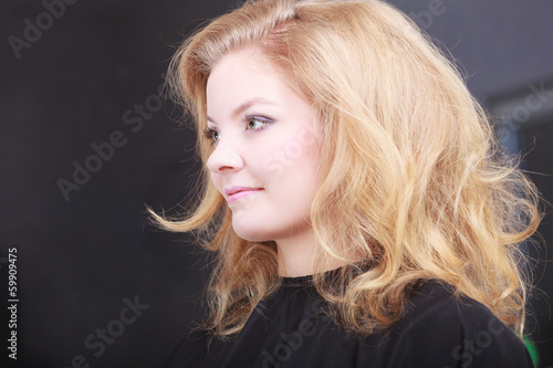 Beautiful blond girl client by hairdresser in hair beauty salon
