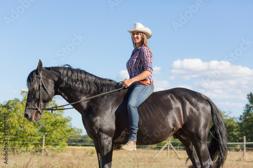 Cowgirl Riding a Black Stallion Horse