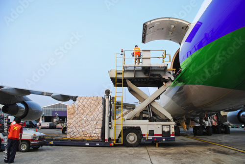 loading goods to cargo plane at airport photo