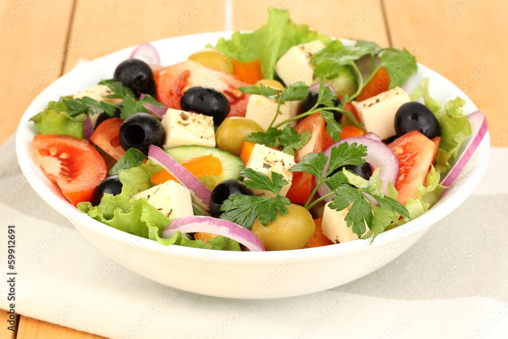 Fresh salad in plate on wooden table