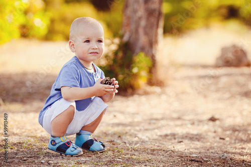 Little toddler boy walking in summer park outdoor