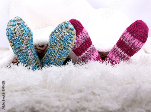 Legs in colorful socks on white carpet background