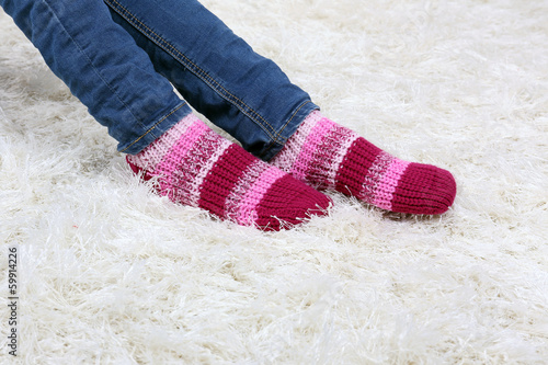 Female legs and  colorful socks on white carpet background