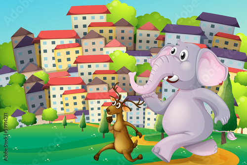 A deer and an elephant running at the hilltop across the tall bu