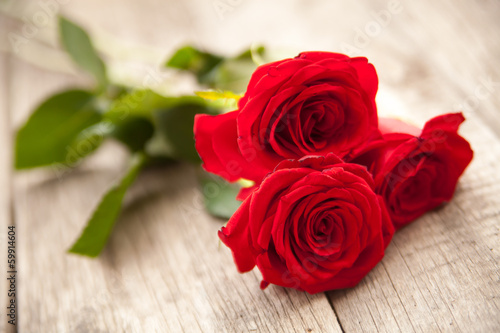 Red roses on wooden background