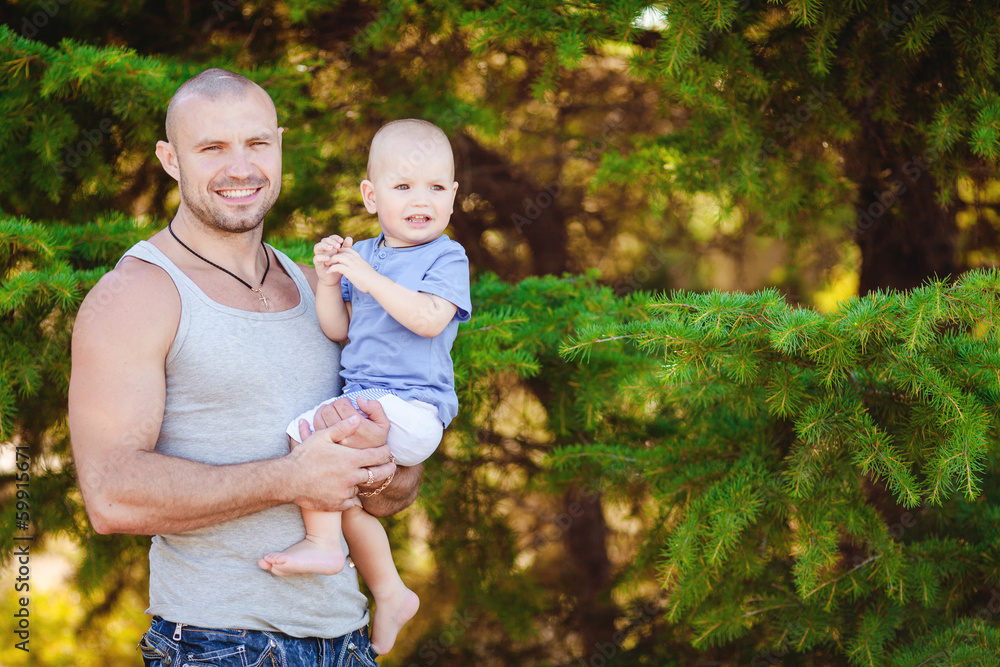 Fototapeta premium Portrait of father cuddling his son during summer vacation